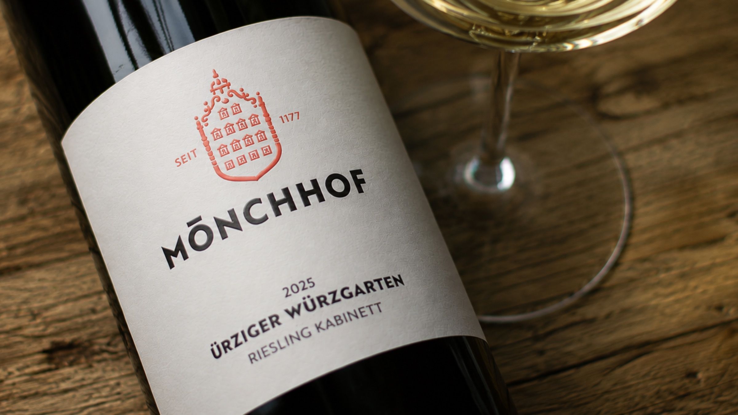 Eine Flasche Mönchhof Riesling mit einem gefüllten Weinglas